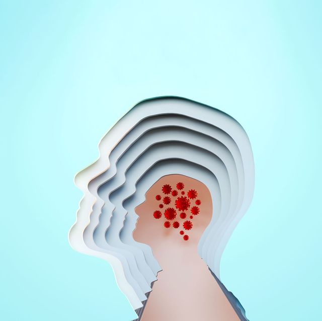 paper sculpture of cutouts of a human head profile with covid viruses where the brain is