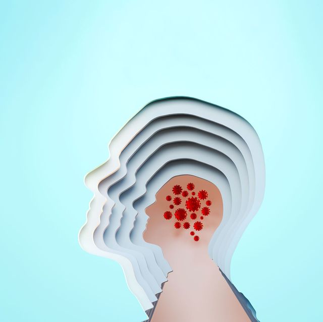 paper sculpture of cutouts of a human head profile with covid viruses where the brain is