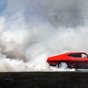 red car moving out of frame burning rubber red car moving out of frame burning rubber