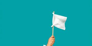 hand sticking out of pile of white tissues with white tissue on a stick like a surrender flag
