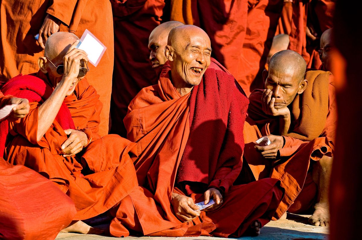 monk in orange robe laughing