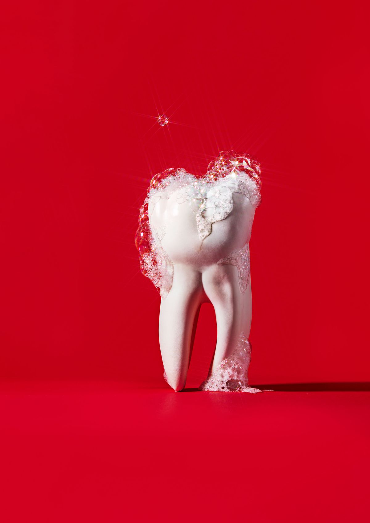 tooth with foam on it against red background