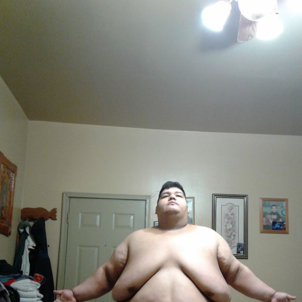 obese man with arms out at home
