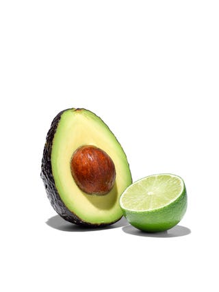 avocado half with pit and lime