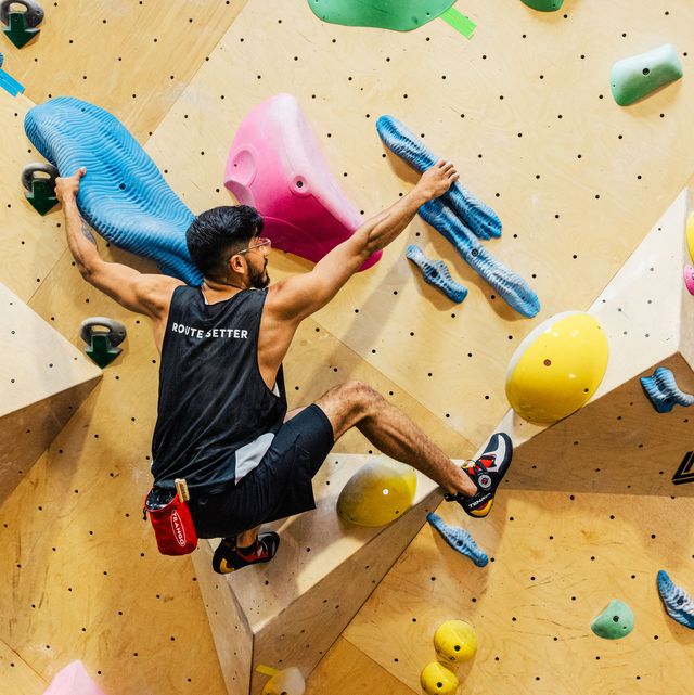 juan guardiola clinging to two holds on a bouldering wall