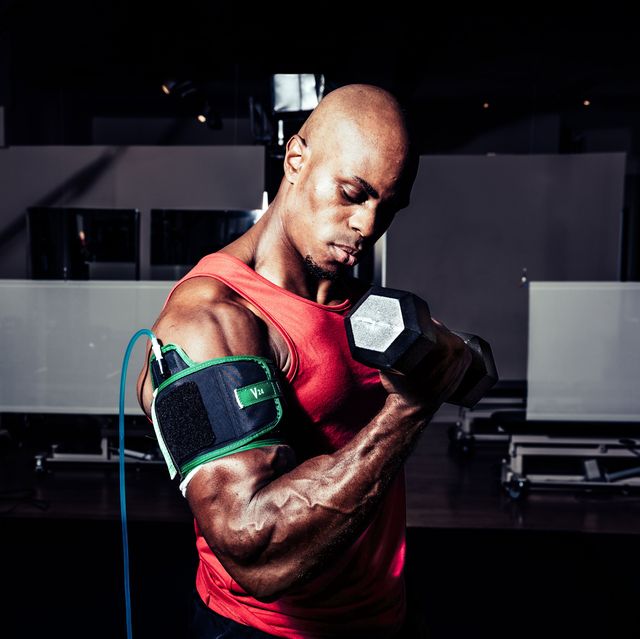james mcmillan does a biceps curl while arm is in a blood flow restriction strap
