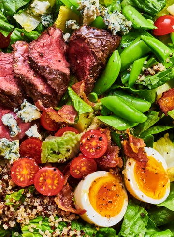 a colorful salad featuring slices of beef cherry tomatoes greens and boiled eggs