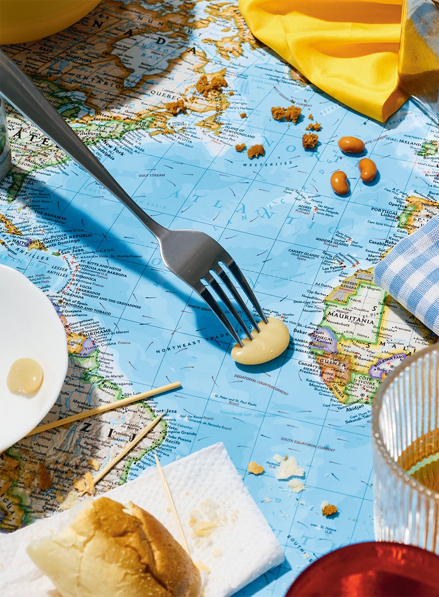 fork grabbing nut off dinner table with world map. global diet. mediterranean diet.