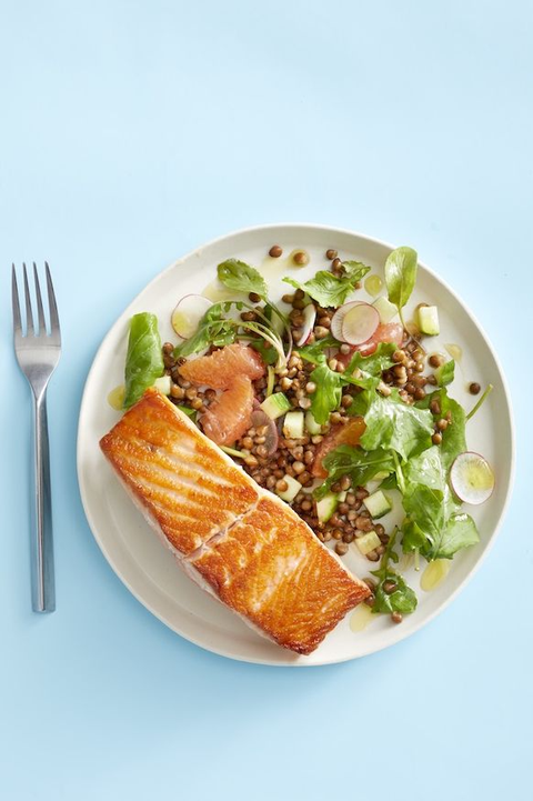 salmon with grapefruit and lentil salad on light blue table