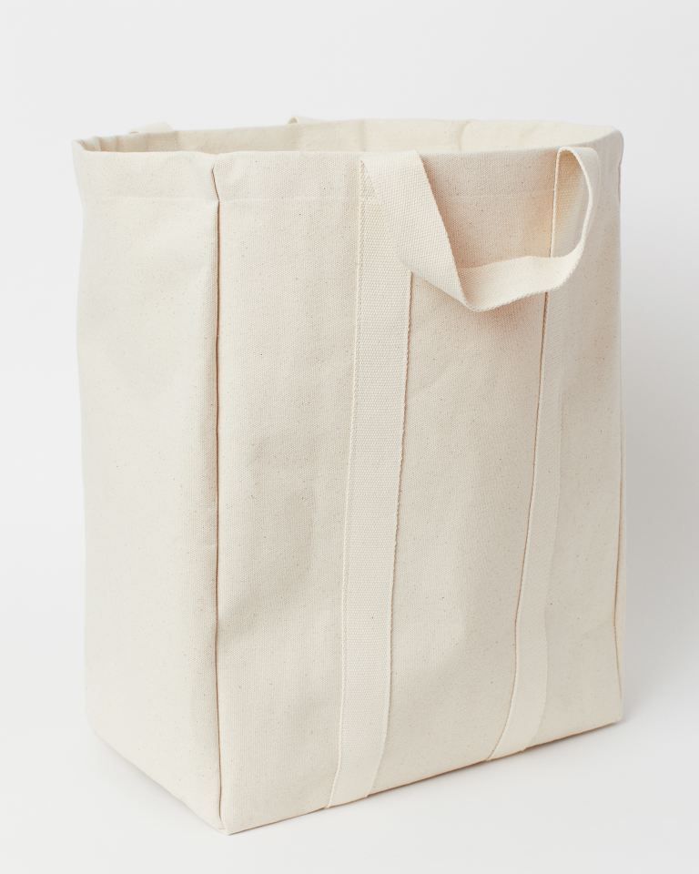 laundry bag in canvas made from a cotton blend with two handles at the top thinner top section in woven fabric with a drawstring closure plastic coating inside depth 25 cm width 40 cm height 43 cm