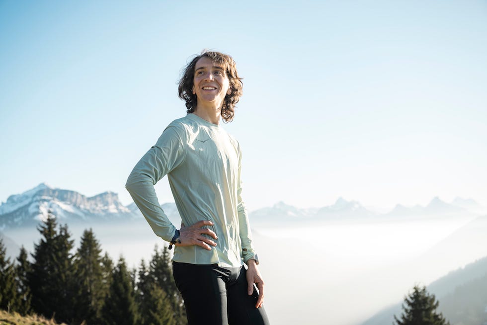 person standing outdoors in athletic clothing with a mountainous background