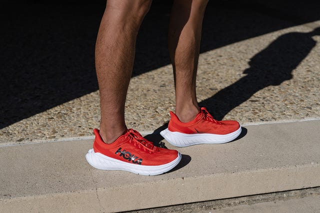 piernas de corredor con las zapatillas de running de hoka one one en color rojo y blanco