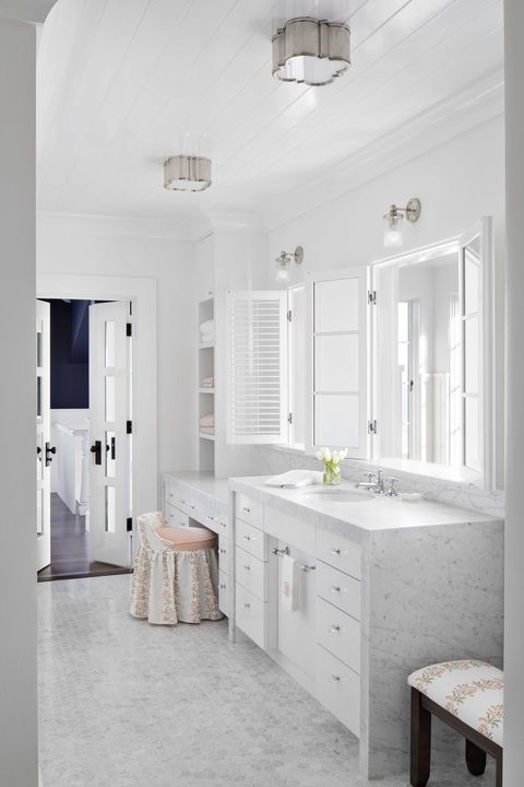 marble bathroom, marble countertops, small marble hexagonal tiles, white cabinets, white mirror, vanity seat and stool