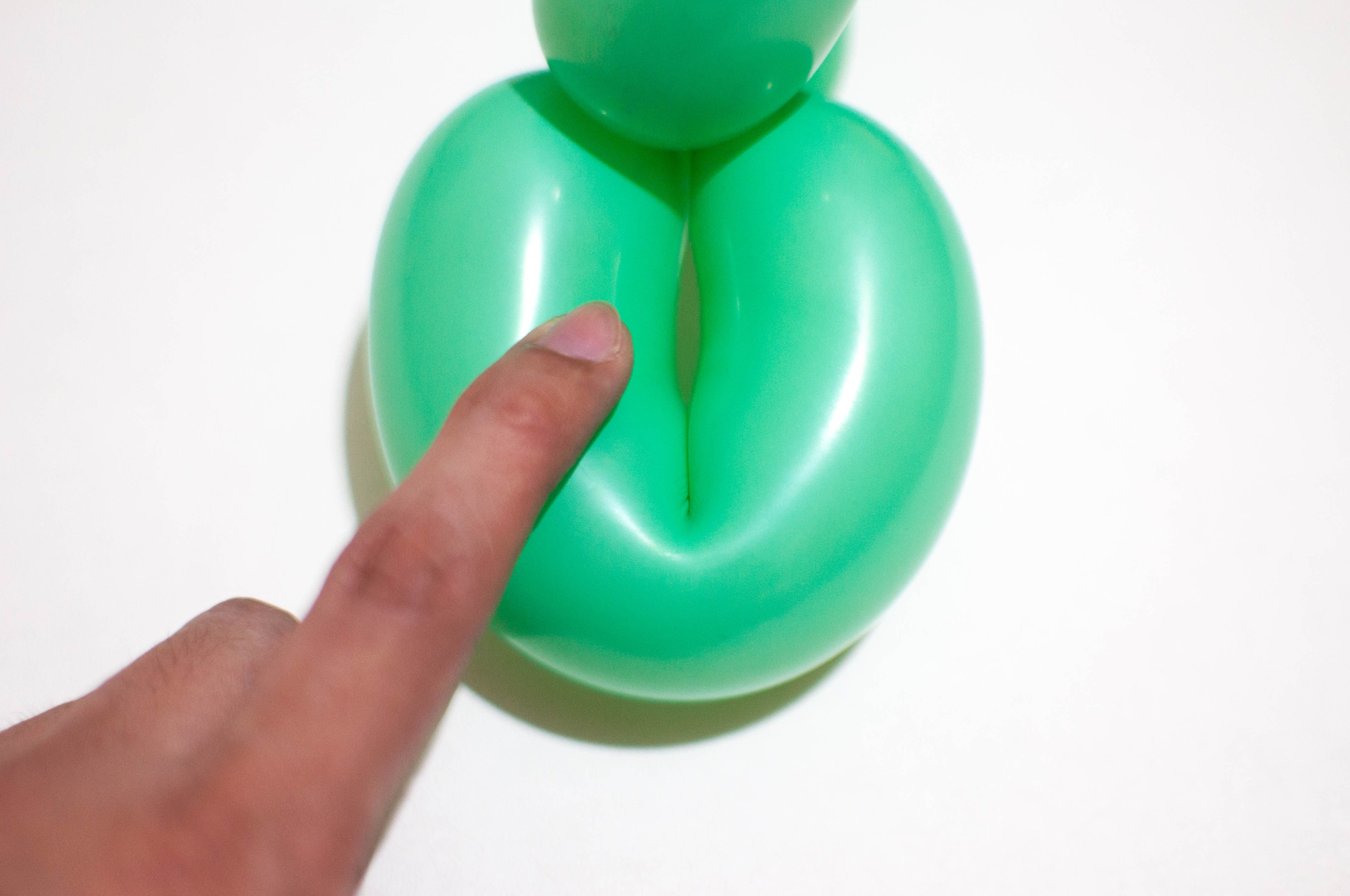 holding a green balloon against white background a concept of female vagina