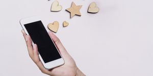 Holding a smartphone with hearts coming out