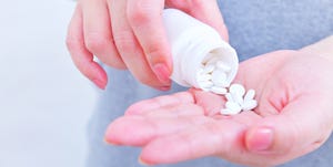 Holding medicine bottle and pour in hand