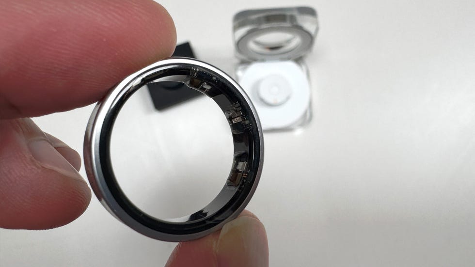 close up showing someone holding a silver smart ring