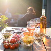 holiday summer brunch party table outdoor in house backyard with appetizer glass of rose wine fresh drink and organic vegetables