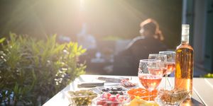 holiday summer brunch party table outdoor in house backyard with appetizer glass of rose wine fresh drink and organic vegetables