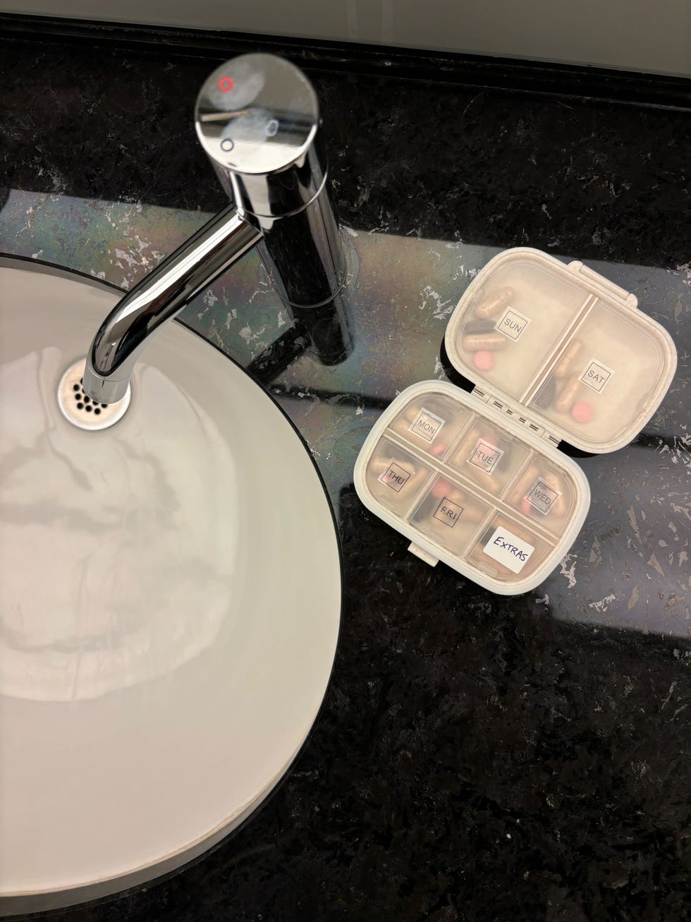 holii travel pill organizer on a sink counter