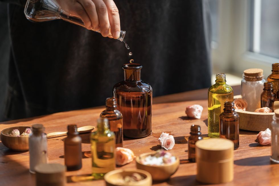 woman preparing holistic skincare using different types of oil salt and essences