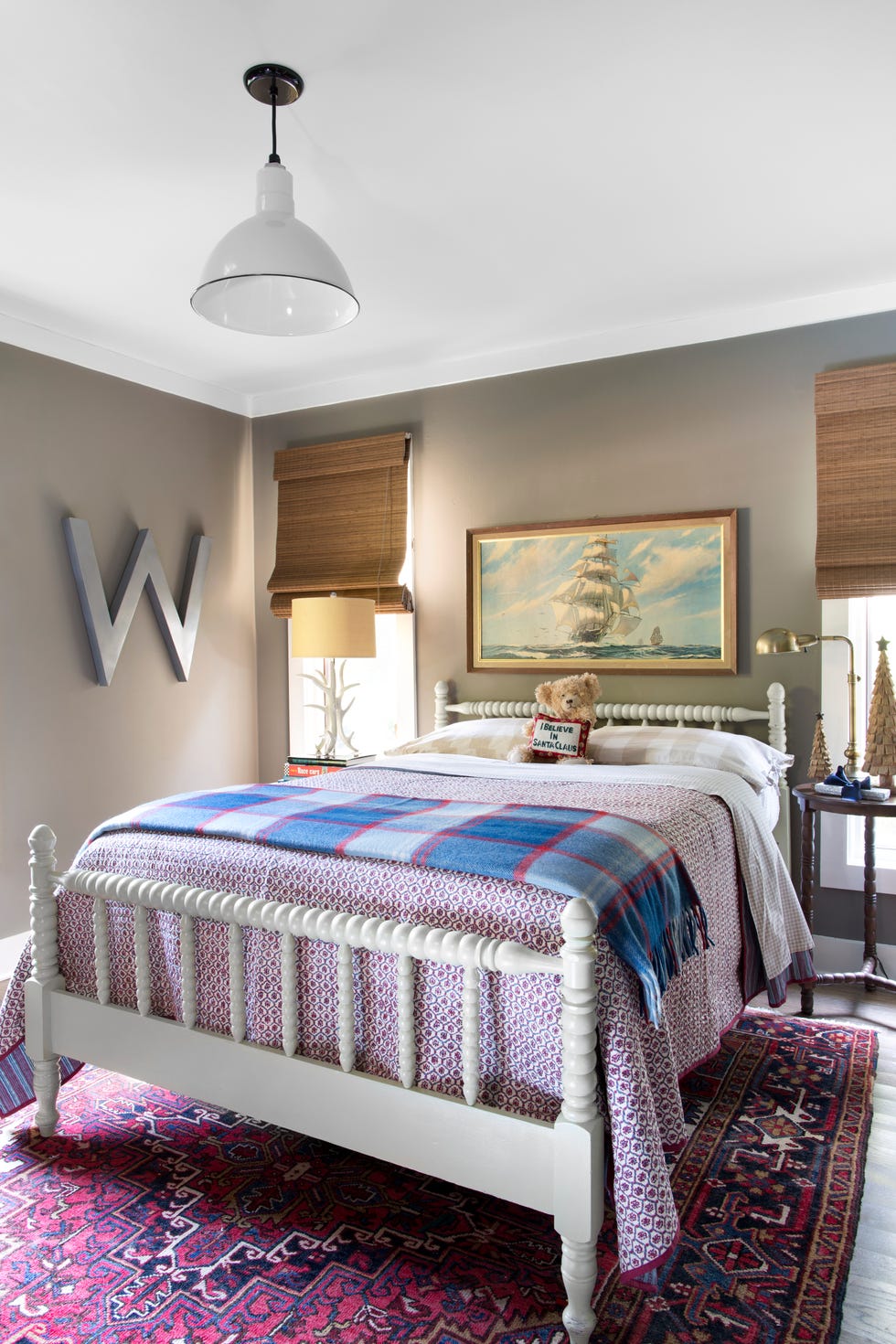 tan bedroom with white spool bed and ship painting above bed