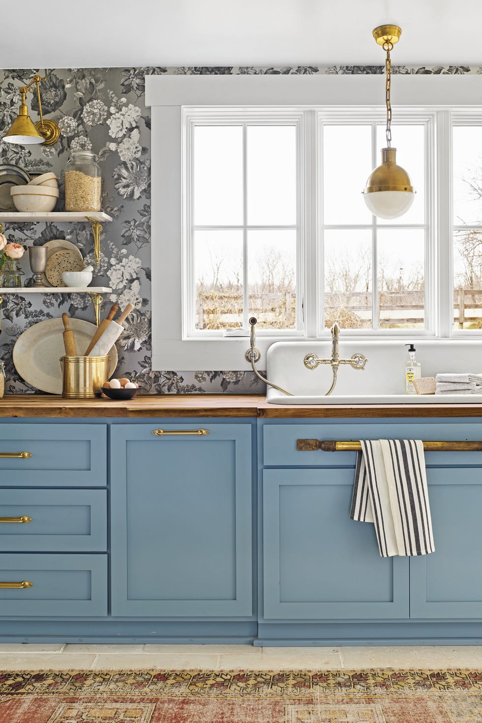 kitchen with blue cabinets and black and white wallpaper