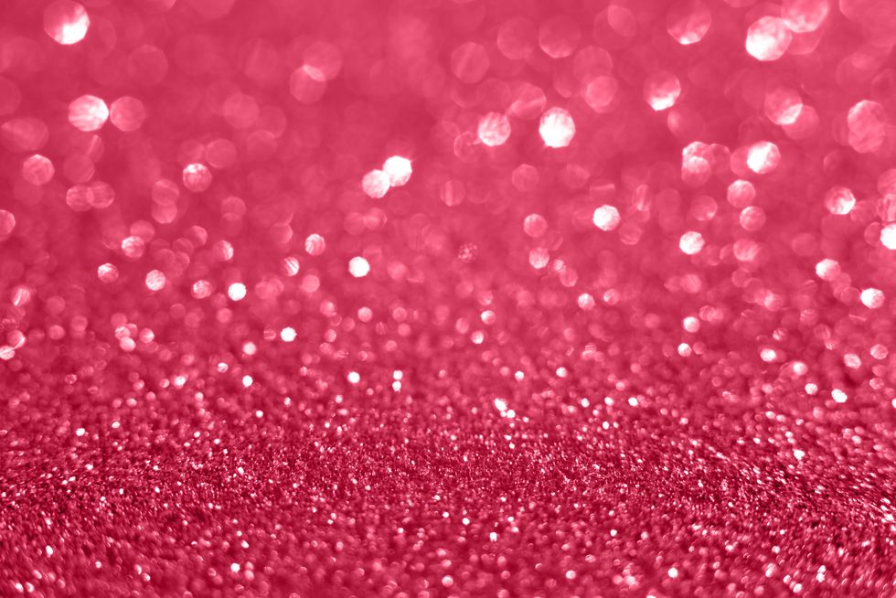 holographic glitter sparkling background with selective focus full frame shot of christmas lights and glitters demonstration of color of the year 2023 color of the year viva magenta