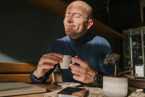 un hombre disfruta tomando una taza de café