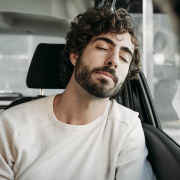 un hombre da una cabezada durante un viaje en coche