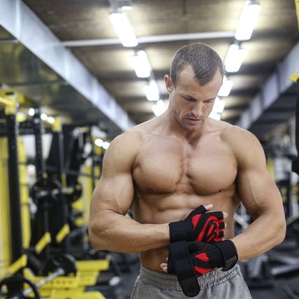 Un hombre fuerte con ropa deportiva tiene un día de entrenamiento en el  gimnasio.