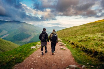 hombres caminando por montaña con mochila