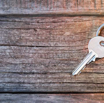 House Key And Keychain On Wooden Table