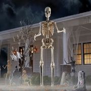 12 foot skeleton standing in yard with other spooky decorations