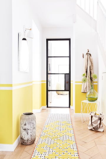 hallway with a black framed door, walls are painted yellow half way up from the bottom line