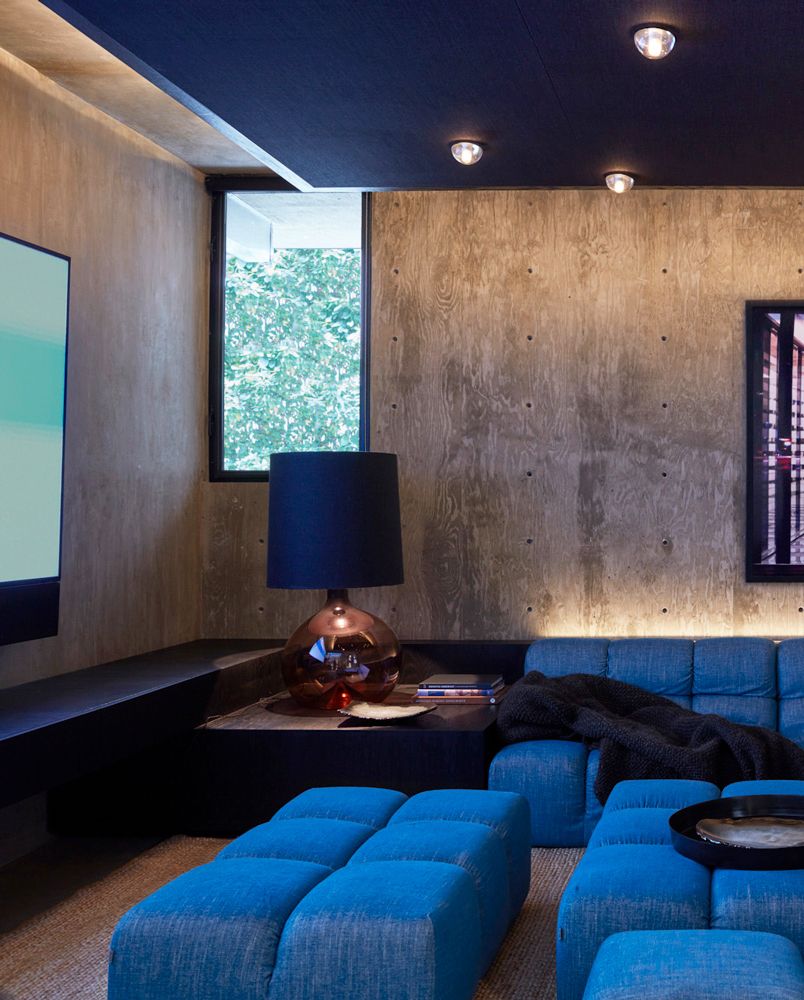 home theater with blue seating and concrete walls