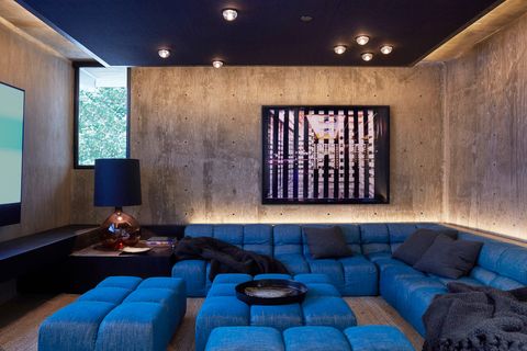 home theater with blue seating and concrete walls