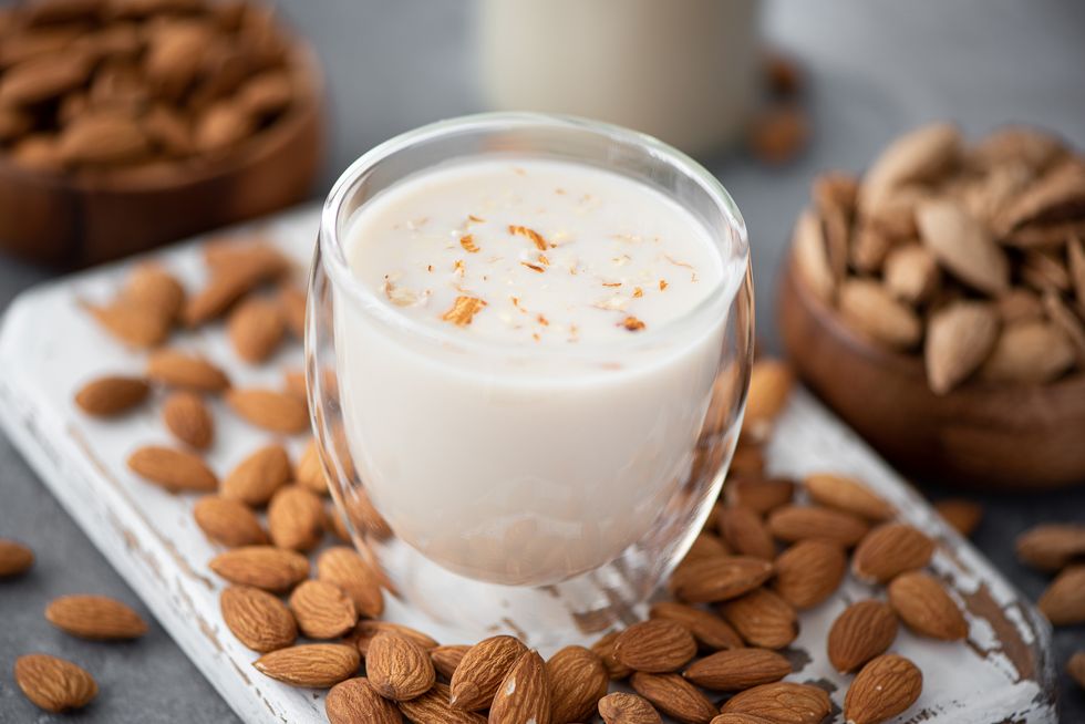 homemade almond milk in a glass on a wooden board