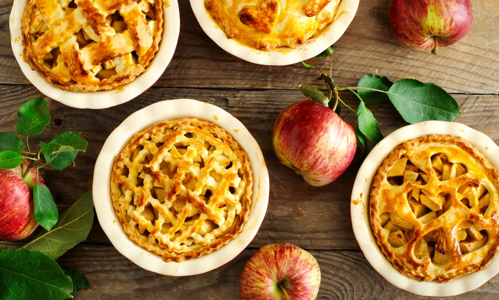 homemade apple pies with apples on a wooden table