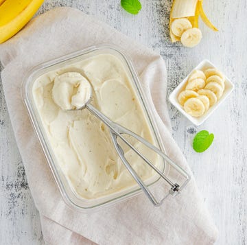 Homemade banana ice cream in a glass container with a spoon for ice cream on a wooden background. Healthy dessert. Horizontal, top view, copy space. homemade banana ice cream in a glass container with a spoon for ice cream on a wooden background healthy dessert horizontal, top view, copy space
