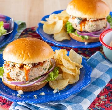 homemade chicken burgers on blue plates with potato chips