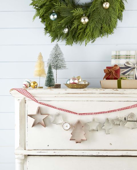 holiday garland made from vintage christmas cookies cutter that are hung on a mantel