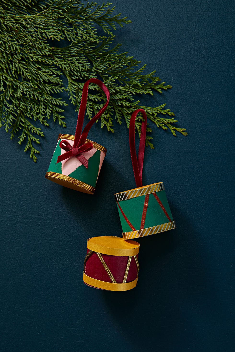 homemade christmas ornaments, small toy drums with red ribbons attached