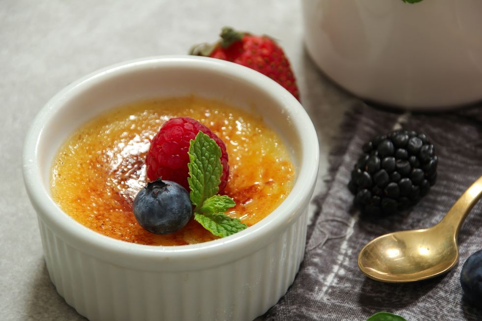 homemade classic creme brulee with burnt sugar berry topping, selective focus