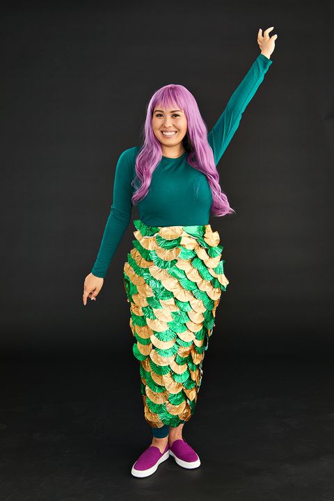 homemade halloween costumes, woman wearing a long light purple wig with bangs, a forest green top and shimmery skirt replicating a mermaid tail