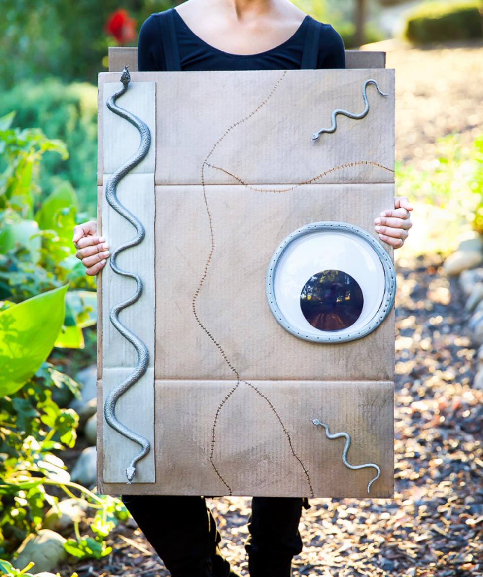 homemade halloween costumes, child holding a diy spellbook