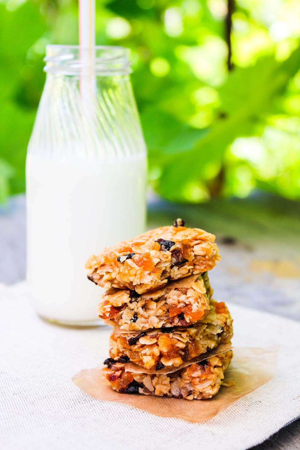 homemade muesli bars with oat flakes, dried apricot, plums, raisin served with a bottle of fresh milk, selective focus healthy eating healthy snack