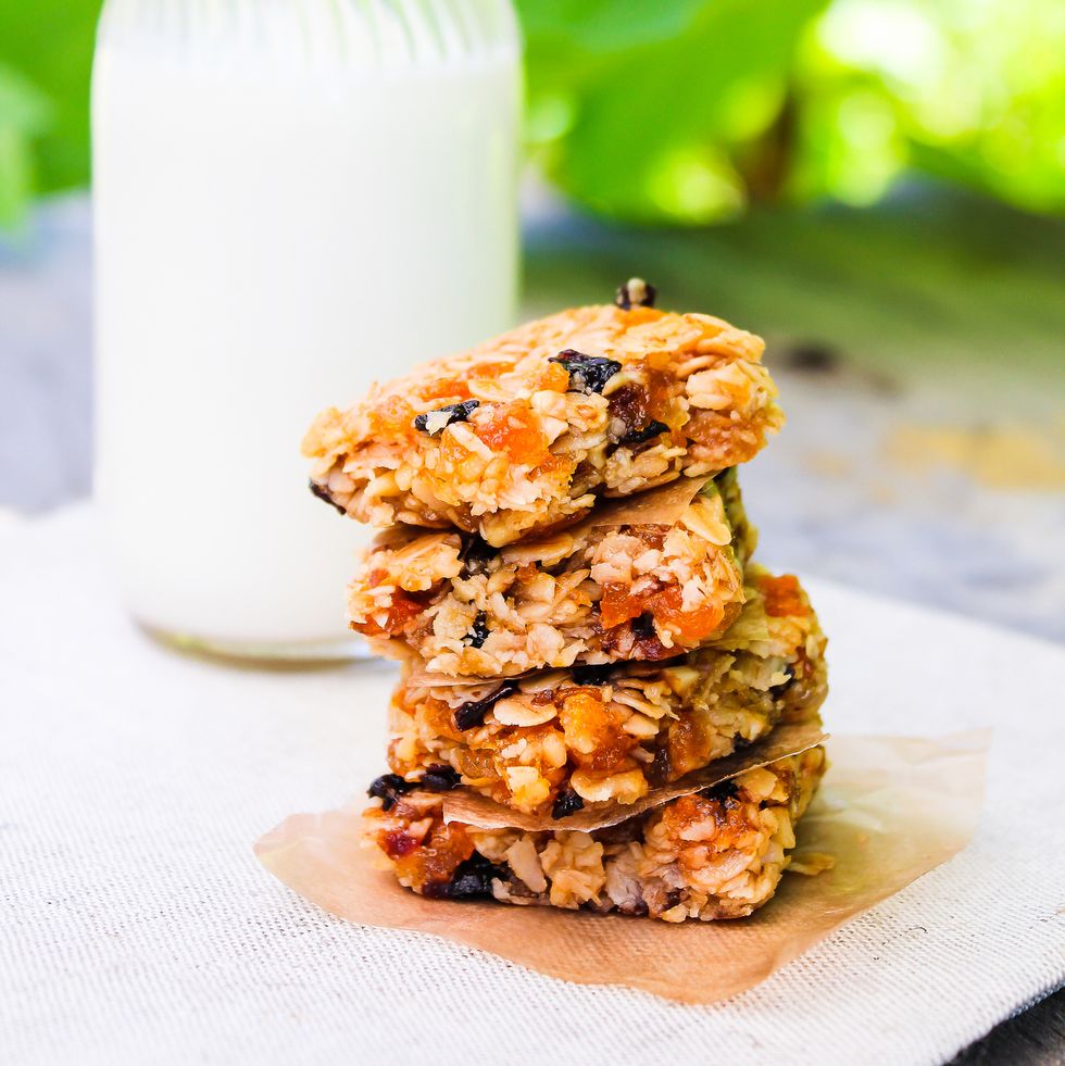 homemade muesli bars with oat flakes, dried apricot, plums, raisin served with a bottle of fresh milk, selective focus healthy eating healthy snack