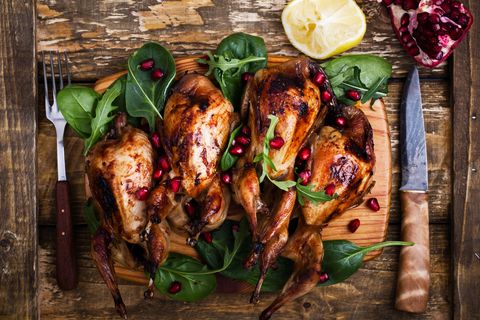 Homemade sticky roast quail served with  green salad and pomegranate seeds