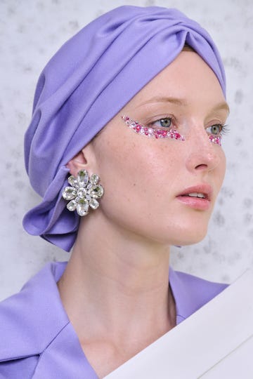 a woman wearing a purple headdress and a purple dress